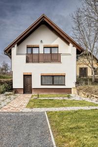 a white house with a balcony on top of it at Hébér Ház in Románd