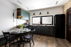 a kitchen with a table and chairs and a sink at Hébér Ház in Románd