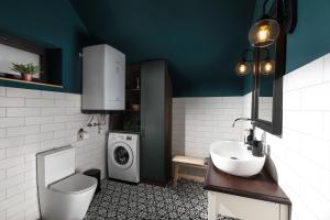 a bathroom with a sink and a washing machine at Hébér Ház in Románd +7 photos