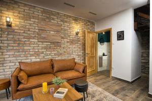 a living room with a couch and a brick wall at Hébér Ház in Románd