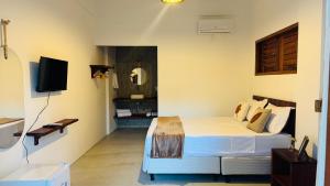 a bedroom with a bed and a television in it at Vila Marina Icaraizinho in Icaraí