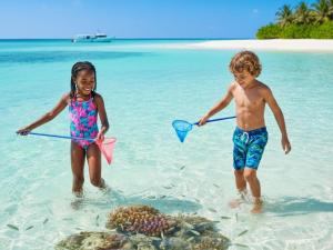 two children playing in the water on a beach at Bougain Villa Gemanafushi in Gemanafushi
