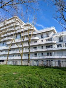 a white building with trees in front of it at Ti Malo - Appartement proche plage Dunkerque in Dunkerque