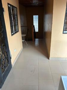 a hallway of a building with a door and a tile floor at Room 4 in Serekunda