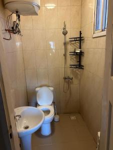a bathroom with a toilet and a sink at Room 4 in Serekunda