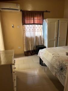 a bedroom with a bed and a window at Room 4 in Serekunda