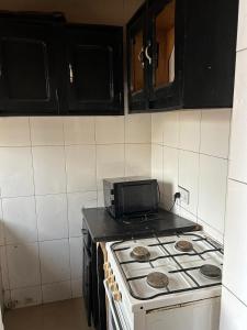 a kitchen with a stove with a microwave on it at Room 4 in Serekunda +3 photos