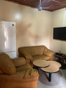 a living room with a couch and two tables at Room 4 in Serekunda