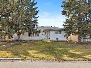 a white house with trees in the yard at Cosmic Game Room, Yard & Close to WEM in Spruce Grove