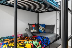 a bedroom with a bunk bed with a spiderman bedspread at Cosmic Game Room, Yard & Close to WEM in Spruce Grove