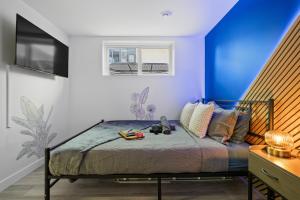 a bedroom with a bed with a blue wall at Cosmic Game Room, Yard & Close to WEM in Spruce Grove
