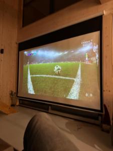 a television screen with a baseball game on it at Chill ChaTka Osowiec Las&SPA pod Warszawą in Osowiec