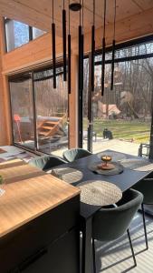 a dining room with a black table and chairs at Chill ChaTka Osowiec Las&SPA pod Warszawą in Osowiec +33 photos