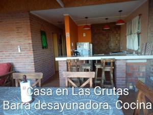 a kitchen with a counter and chairs in a room at Casa en Las Grutas in Las Grutas +9 photos