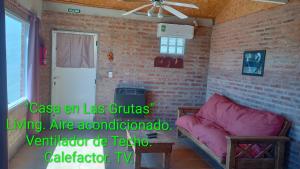 a living room with a couch and a brick wall at Casa en Las Grutas in Las Grutas