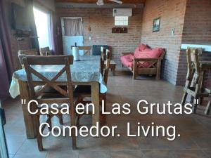 a dining room with a table and chairs and a brick wall at Casa en Las Grutas in Las Grutas