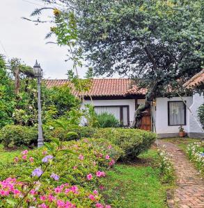 a house with pink flowers in the yard at Chalet Andino Sesquile in Suesca