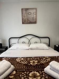 a bed with a headboard and a painting on the wall at Blue two apartment in Kavála