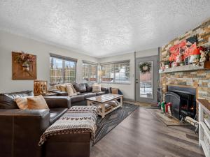 a living room with a couch and a fireplace at Giant Steps 12 Rustic Retreat ski in out in Brian Head