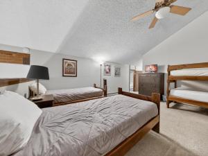 a bedroom with two beds and a ceiling fan at Giant Steps 28 Ski in out in Brian Head +53 photos