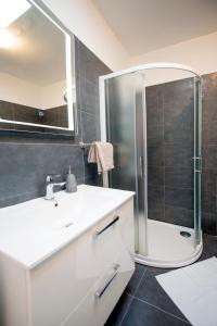 a bathroom with a white sink and a shower at Apartman Denis in Pula +8 photos