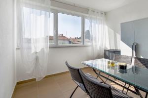 a dining room with a glass table and chairs at Apartman Denis in Pula