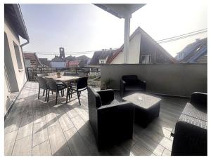 a patio with a table and chairs on a balcony at Sérénité Alsacienne, jardin, terrasse et clim, Nord Alsace in Seltz