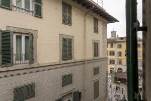 a building with green shutters on the side of it at Delux Via Faenza in Florence