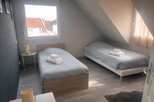 a small room with two beds and a window at Sérénité Alsacienne, jardin, terrasse et clim, Nord Alsace in Seltz