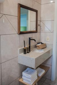 a bathroom with a sink and a mirror and towels at Apartamento Brisa in Veranópolis +20 photos