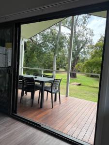 a patio with a table and chairs on a deck at Denman Van Village in Denman