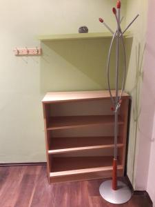 a book shelf with a broom in a room at Home Apartman in Debrecen