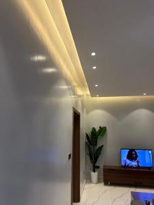 a living room with a tv on a white wall at Bright 1BR Apartment Close to Everything in Kigali +4 photos