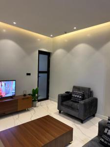 a living room with a chair and a television at Bright 1BR Apartment Close to Everything in Kigali