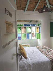 ein Schlafzimmer mit einem Bett in einem Zimmer mit Buntglasfenstern in der Unterkunft Hostal La Cestería Pueblito Boyacense in Duitama