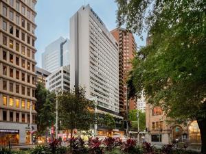 a city street with tall buildings in a city at Novotel Sydney City Centre in Sydney
