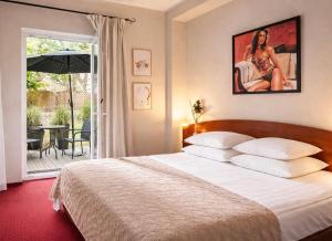 a bedroom with a bed and a patio with an umbrella at Morska Fala in Pobierowo
