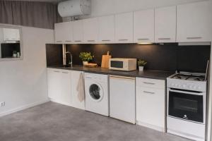 a kitchen with white cabinets and a washer and dryer at Mobil-home LOFT tout équipé Le Castellet les pins doux in Le Castellet