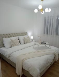 a white bedroom with a large bed and a table at Yes Boss House Divcibare in Divčibare
