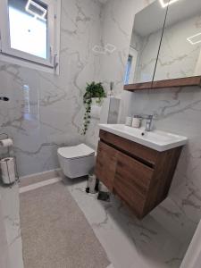 a white bathroom with a sink and a toilet at Yes Boss House Divcibare in Divčibare +6 photos