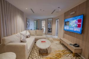 a living room with a couch and a flat screen tv at Grand Line in Tabuk