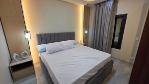 ein Schlafzimmer mit einem großen Bett mit weißer Bettwäsche in der Unterkunft Evrest in New cairo