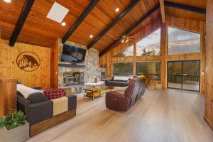 a living room with wooden walls and a large window at Summit Cabin Stunning home Loaded with amenities in Oakhurst