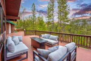 a porch with couches and a table on a deck at Summit Cabin Stunning home Loaded with amenities in Oakhurst