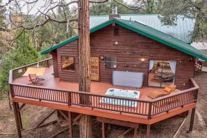 a tree house with a deck in the woods at Summit Cabin Stunning home Loaded with amenities in Oakhurst +44 photos
