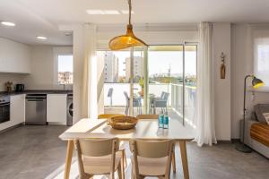 a kitchen and dining room with a table and chairs at AT Ponent I B3 in La Playa de la Torre de Piles