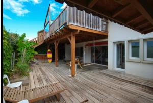 a large wooden deck with a balcony on a house at Bidart centre maison vue mer in Bidart