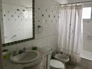 a bathroom with a sink and a toilet and a mirror at Plaza Mitre, departamento 2 dormitorios in San Nicolás de los Arroyos +5 photos