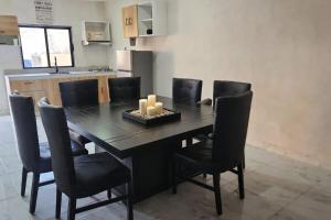 a dining room table with black chairs and candles on it at Quinta el molino in Parras de la Fuente