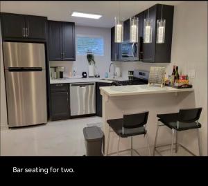 a kitchen with stainless steel appliances and black cabinets at Downtown and Inner Harbor Apartment in Baltimore +12 photos